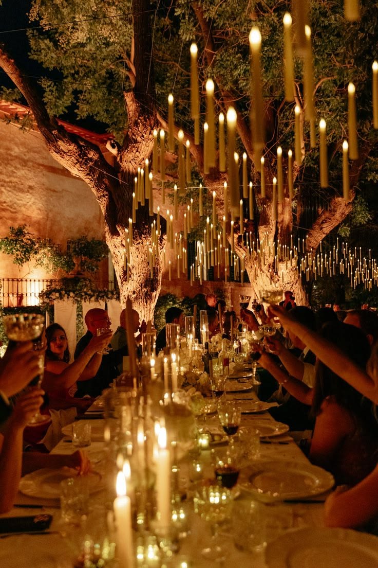 A community gathering bathed in warm light beneath hanging lanterns — Emotional Architecture in practice.